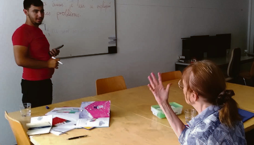 Ricardo, l&#039;un des jeunes du projet «Droit à l&#039;école, droit à un avenir», en séance de soutien scolaire avec Regula, bénévole. / ©DR